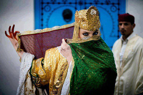 Tunisian bride in traditional gold wedding attire dancing wedding dance
